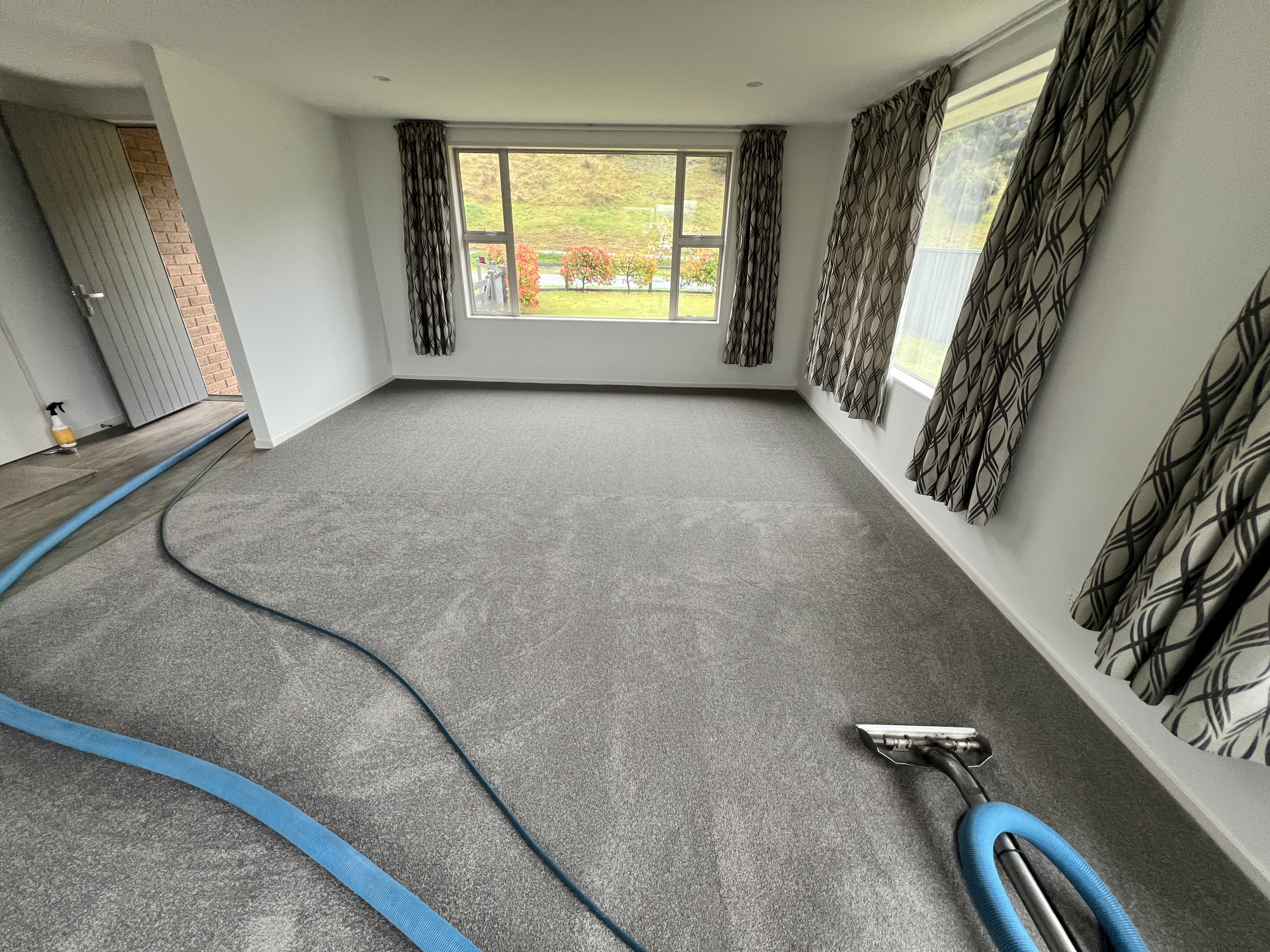 Carpet cleaning equipment working across a carpeted room